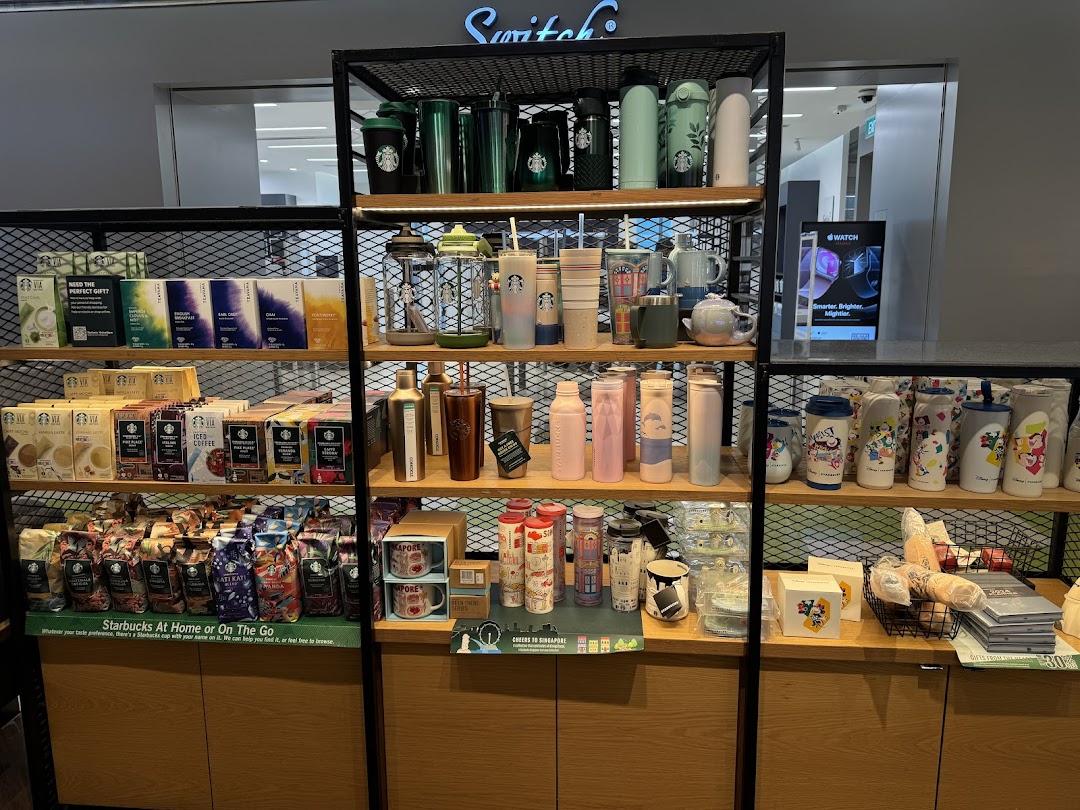 An interior shot of Starbucks displaying various coffee beans, instant coffee, tea, and branded merchandise.