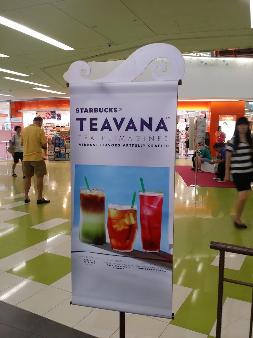 A Starbucks Teavana promotional banner showcasing new vibrant tea beverages in a mall setting.