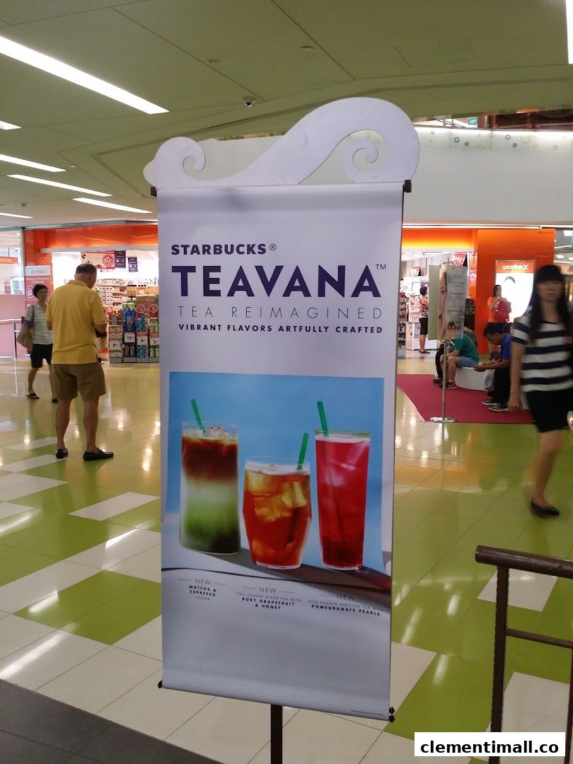 A Starbucks Teavana promotional banner showcasing new vibrant tea beverages in a mall setting.