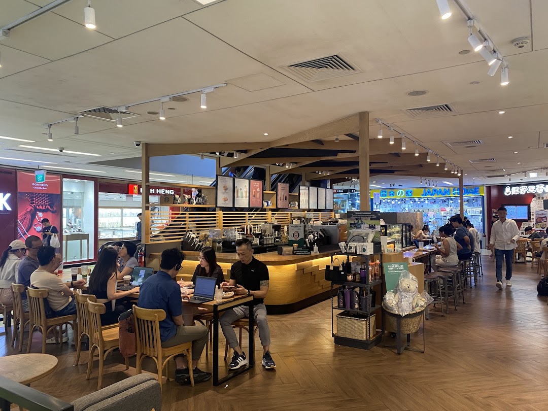 Customers enjoy coffee and work inside a bustling Starbucks cafe with a warm, inviting atmosphere.