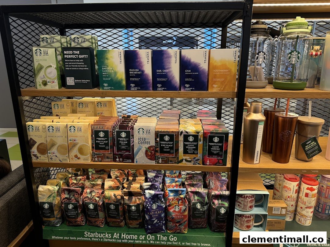 A retail display shelf inside Starbucks, featuring packaged coffee, tea, and branded drinkware.