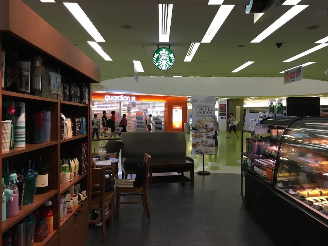Interior view of Starbucks Clementi Mall, showcasing merchandise, seating, and a pastry display.