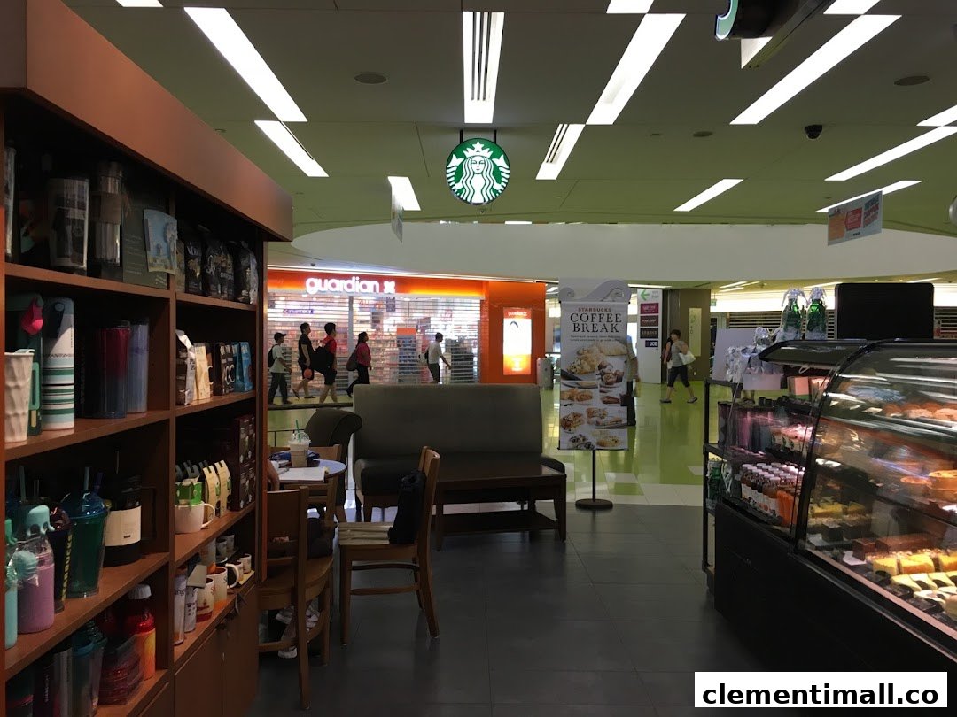 Interior view of Starbucks Clementi Mall, showcasing merchandise, seating, and a pastry display.