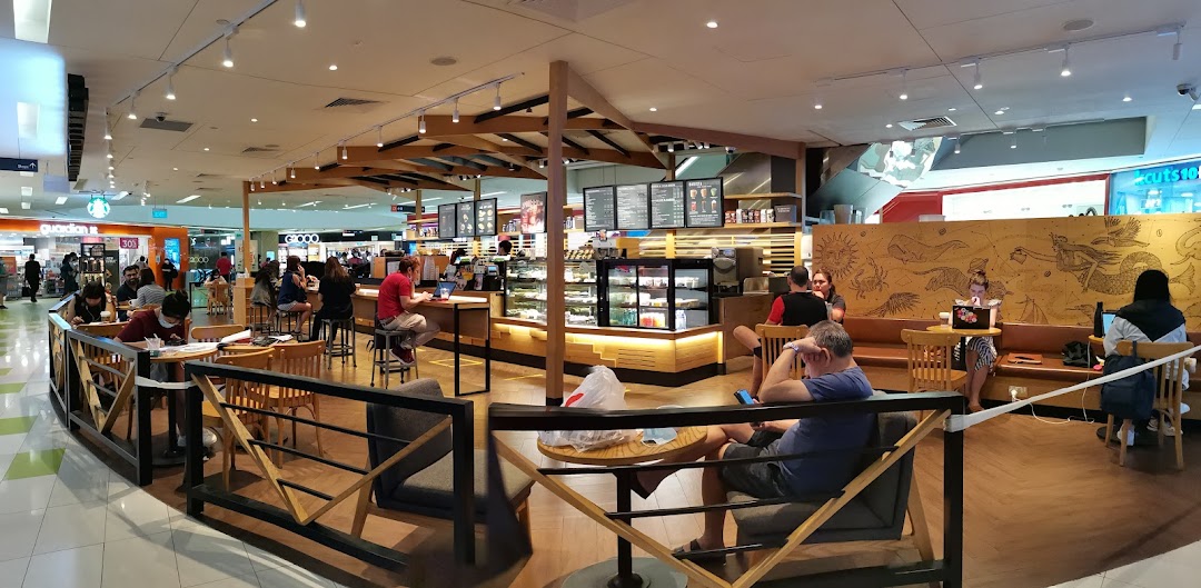 A bustling interior view of Starbucks Clementi Mall with customers enjoying coffee and the cozy ambiance.
