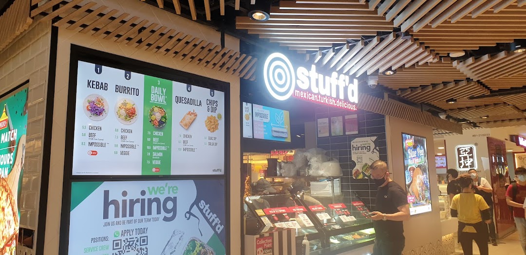 The Stuffd shop front with its bright signage and digital menu board in a bustling mall.