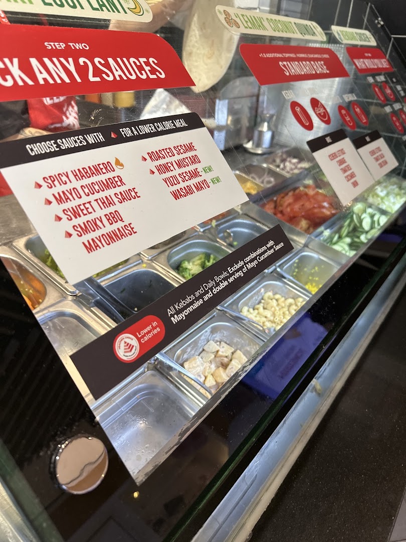 A close-up of Stuffd's food counter displaying fresh ingredients and sauce options.