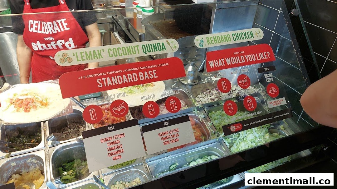 A vibrant counter at Stuffd showcasing fresh ingredients and customizable healthy meal options like kebabs and burritos.
