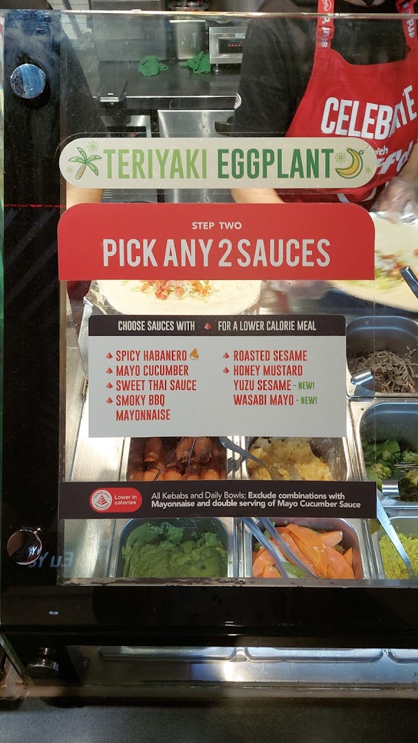 A Stuffd food counter display showing sauce options, a Teriyaki Eggplant special, and customization instructions.