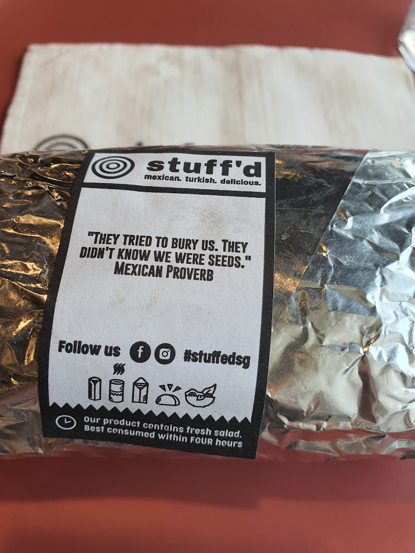 A foil-wrapped food item from Stuffd with a branded label featuring a Mexican proverb.