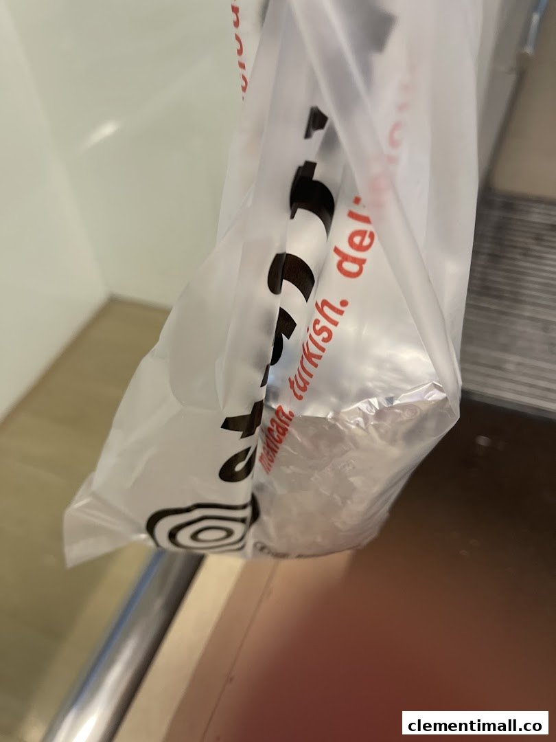 A close-up of a Stuffd take-away bag featuring 'mexican. turkish. deli' text and a foil-wrapped item.