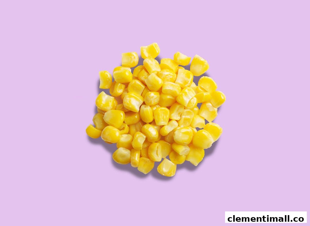 A vibrant pile of golden corn kernels rests on a soft lavender background.