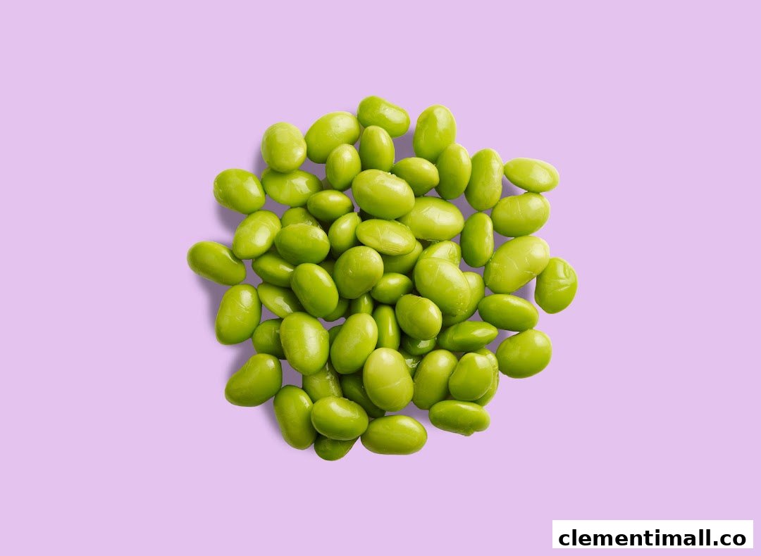 A vibrant pile of fresh green edamame beans rests on a soft purple background.