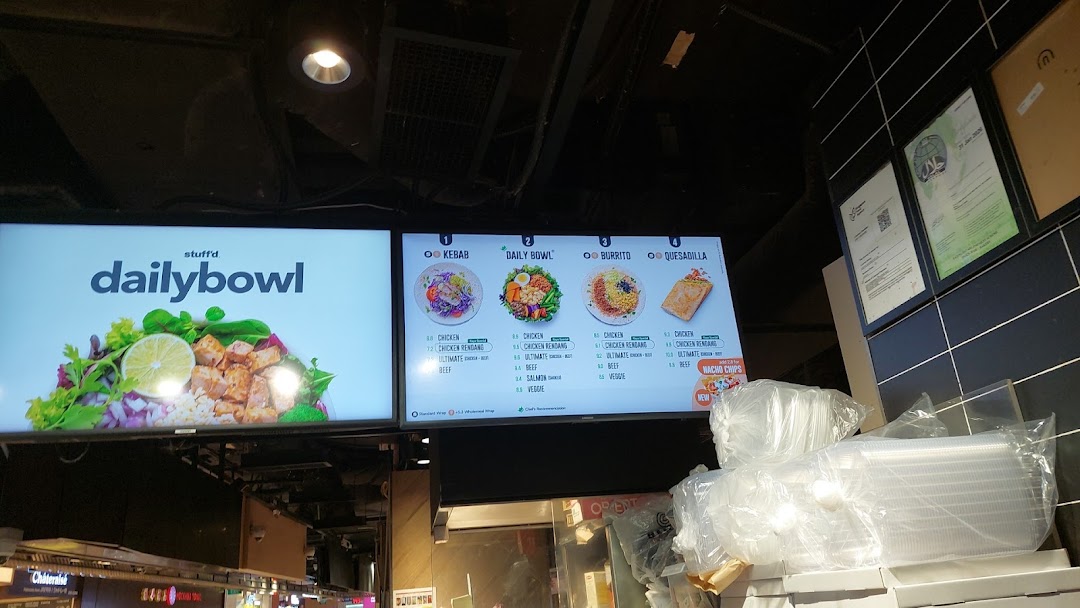 Digital menu boards at Stuffd displaying various customizable kebab, bowl, burrito, and quesadilla options.