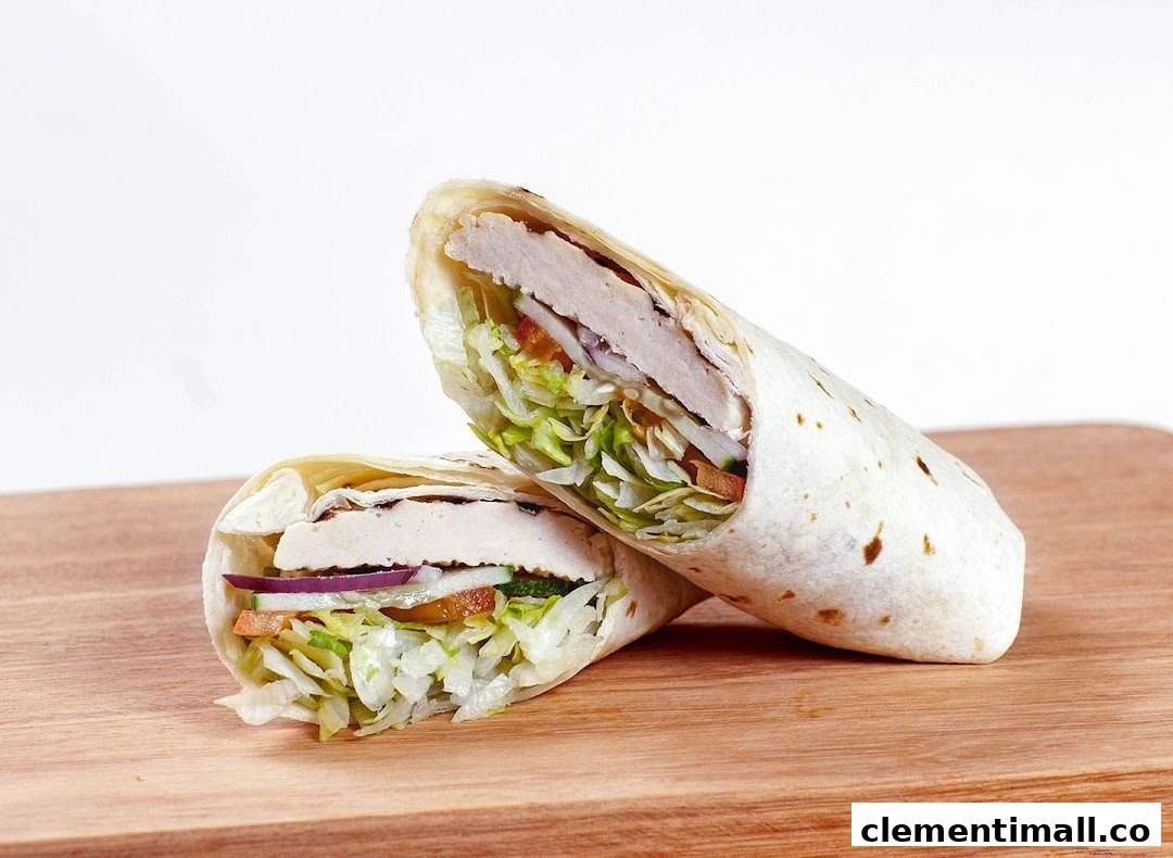 A delicious chicken and vegetable wrap, cut in half, displayed on a wooden surface.