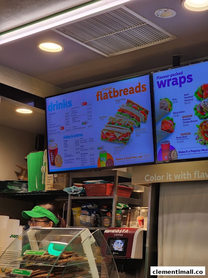 A vibrant digital menu board at Subway, showcasing flatbreads, wraps, drinks, and sides.