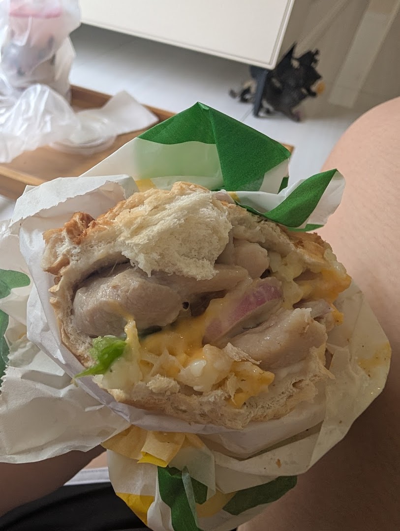 A close-up of a delicious Subway sandwich, revealing fresh ingredients like chicken, cheese, and red onion.