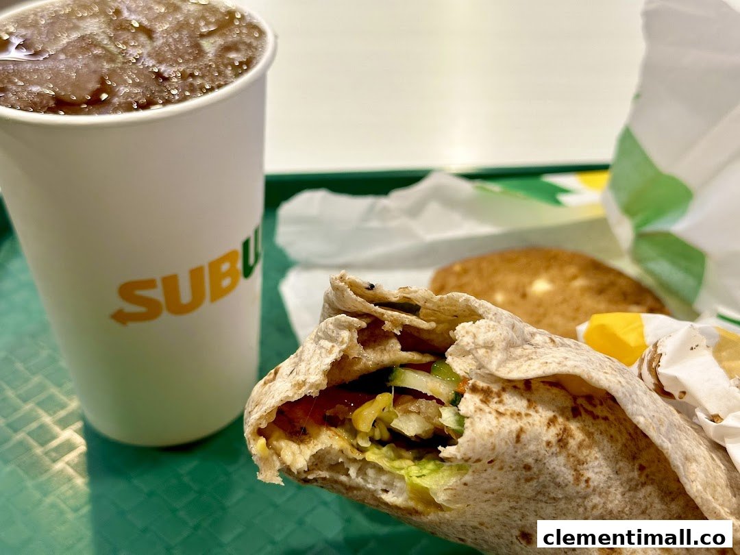 A close-up of a Subway meal featuring a fresh wrap and a refreshing drink on a green tray.