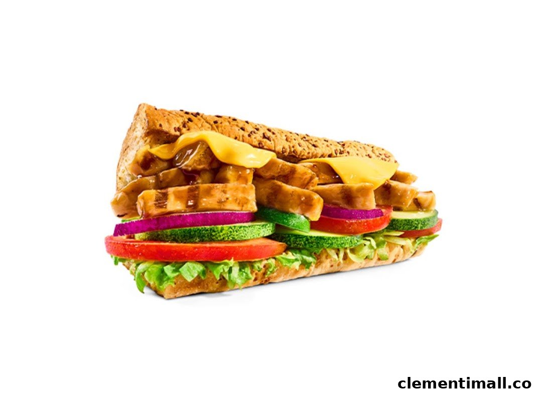 A close-up of a Subway sandwich filled with chicken, melted cheese, and fresh vegetables.