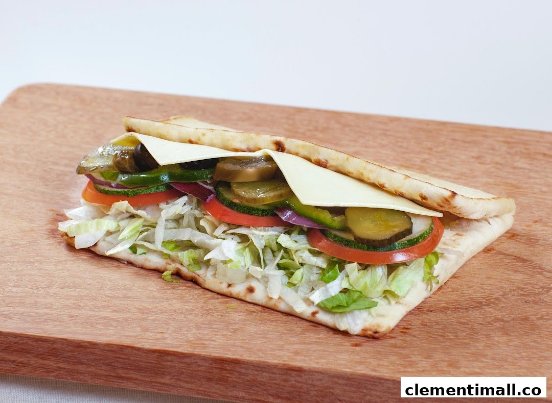 A fresh Subway sandwich with various vegetables and cheese on flatbread.
