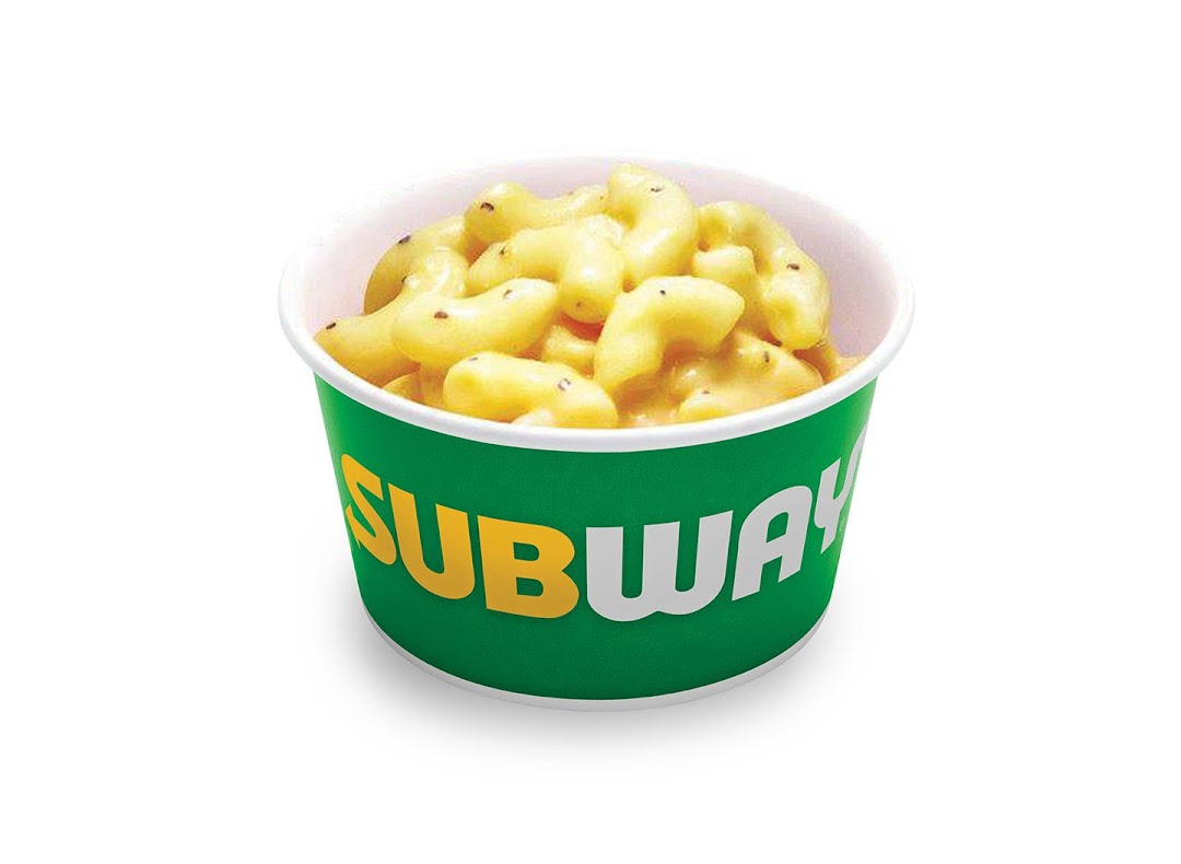 A cup of creamy macaroni and cheese from Subway, isolated on a white background.