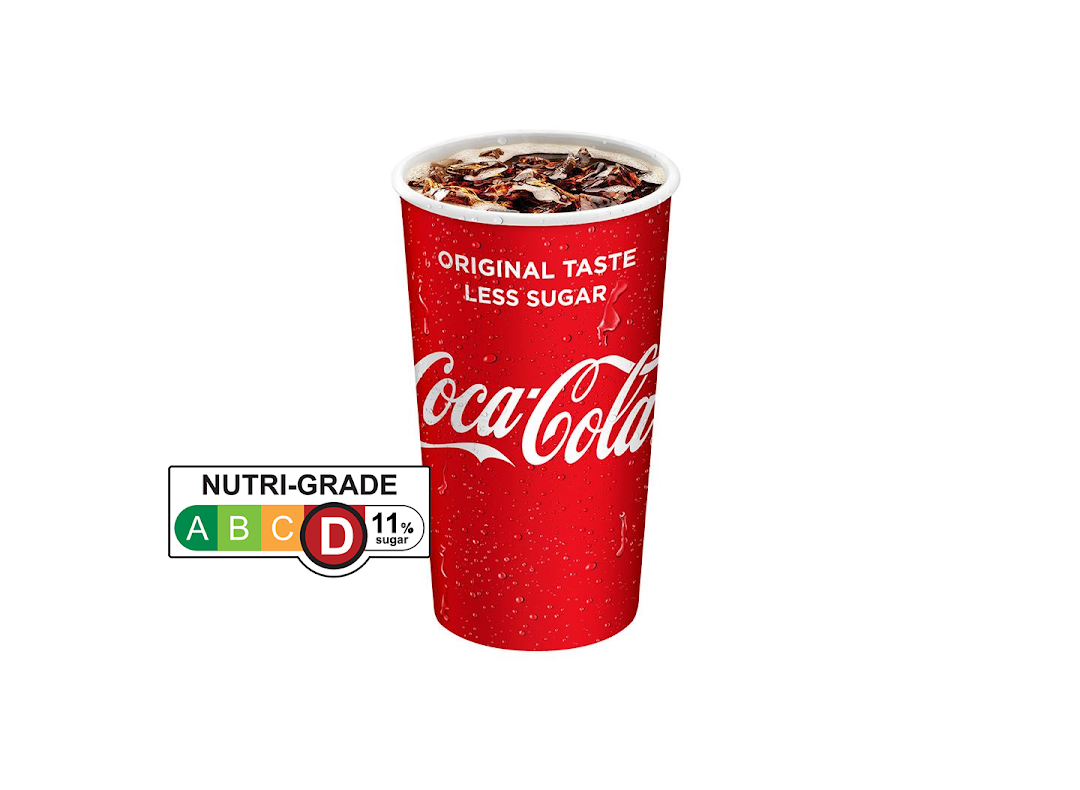 A red Coca-Cola cup with ice and drink, featuring 'Original Taste Less Sugar' and a Nutri-Grade D label.
