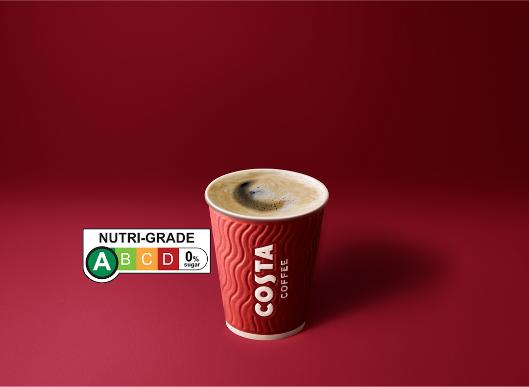 A Costa Coffee cup with a Nutri-Grade label displayed against a vibrant red background.