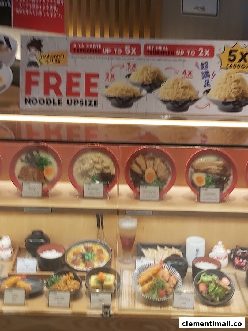 A display of realistic Japanese food models, including noodle dishes and sides, with a promotional banner.