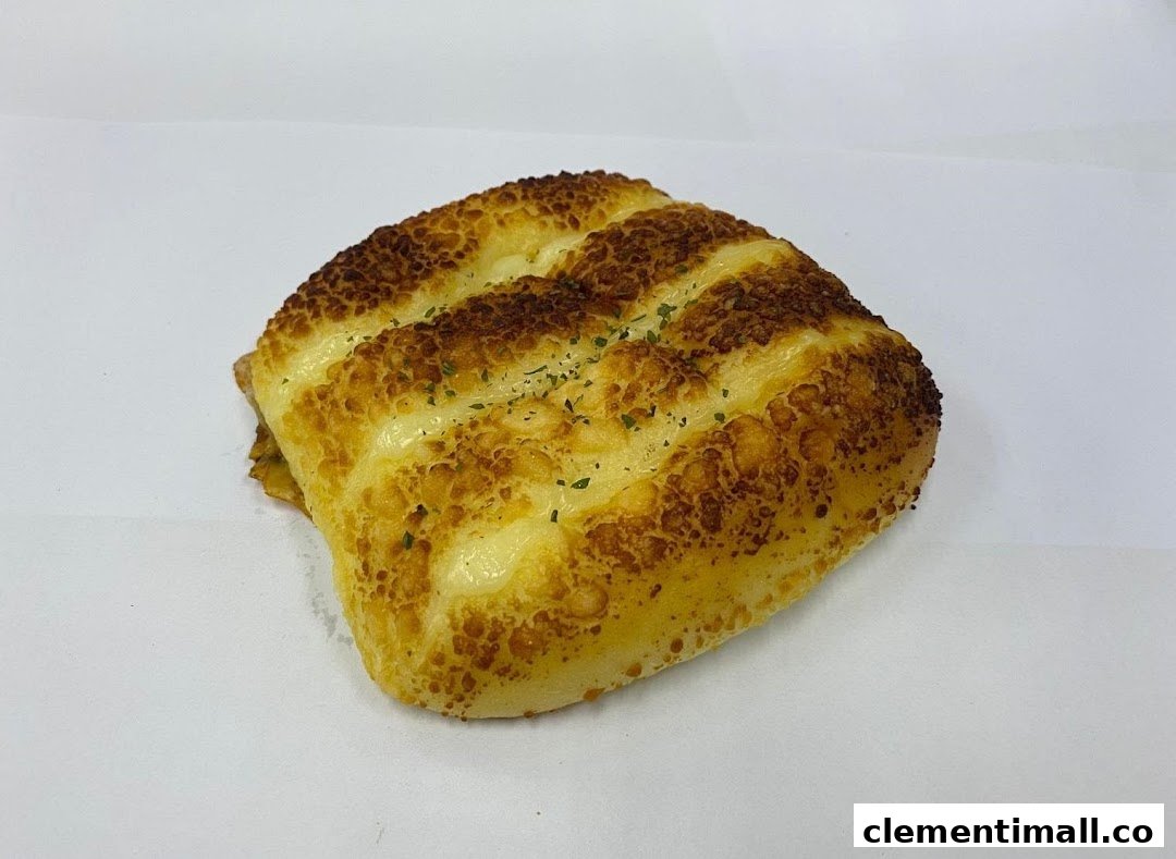 A golden-brown cheese bun with visible cheese pockets and green herbs.