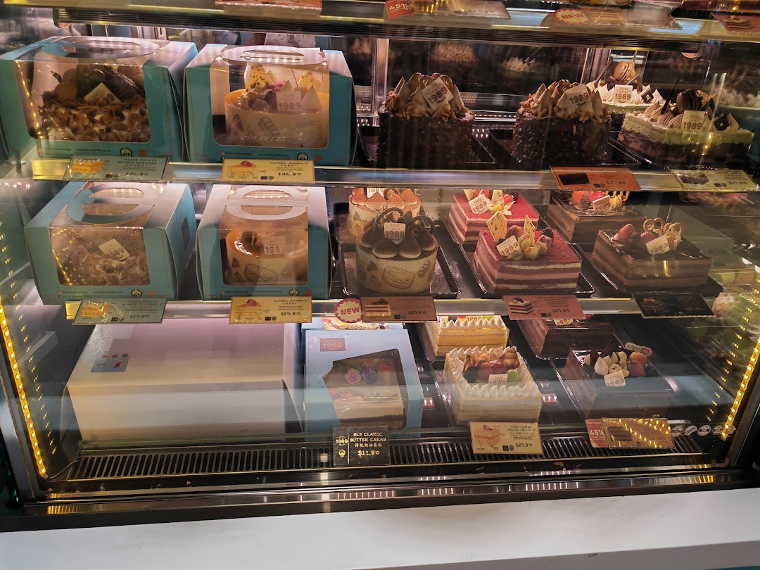 A refrigerated display case filled with an assortment of beautifully decorated cakes and pastries at Swee Heng 1989 Classic.