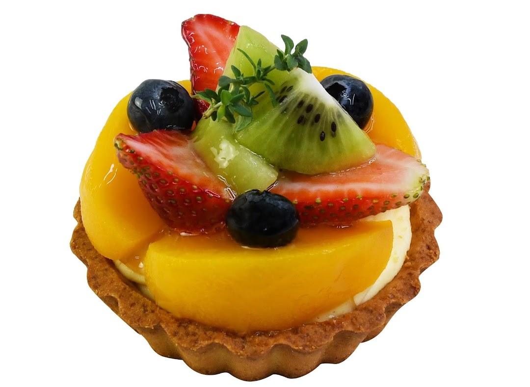 A vibrant fruit tart topped with mango, strawberries, blueberries, and kiwi.