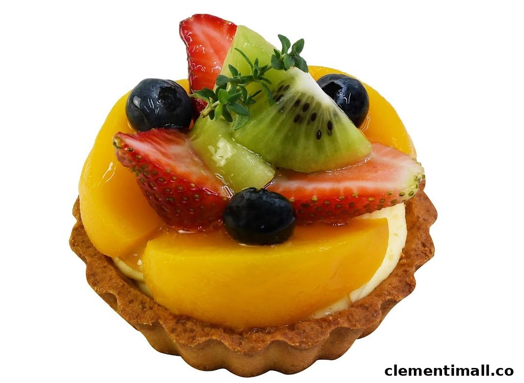 A vibrant fruit tart topped with mango, strawberries, blueberries, and kiwi.