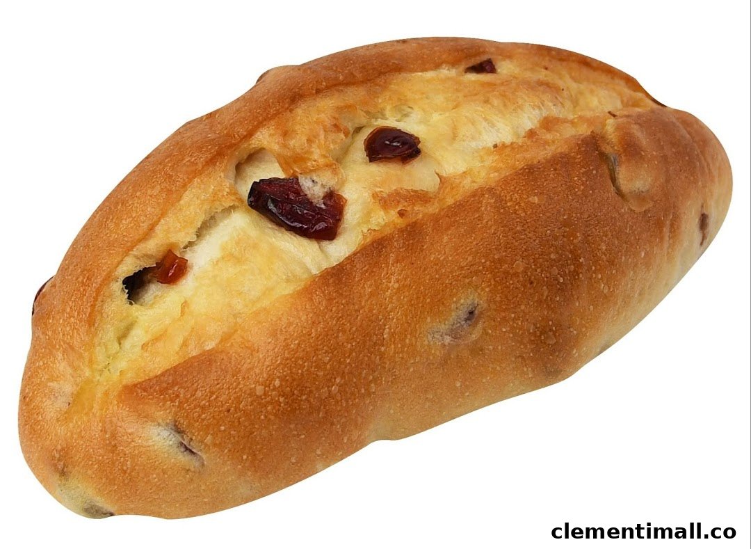 A golden-brown baked bun with a creamy filling and visible dried cranberries.