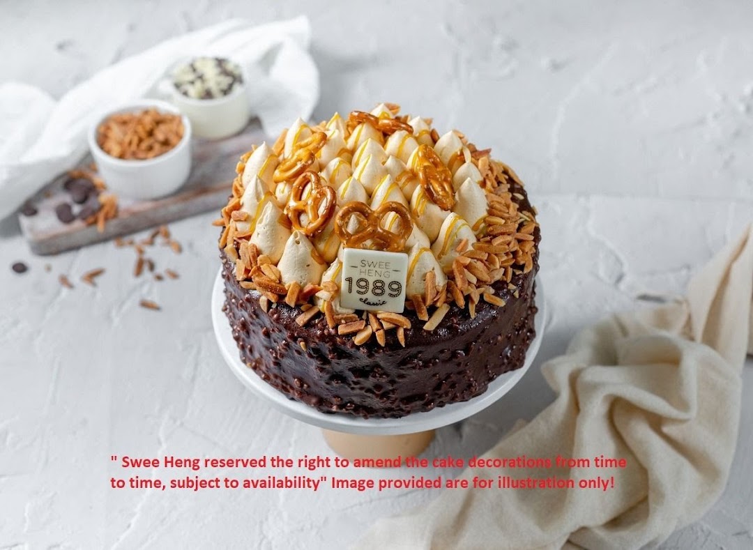 A chocolate cake with cream, pretzels, and almonds on a white stand.