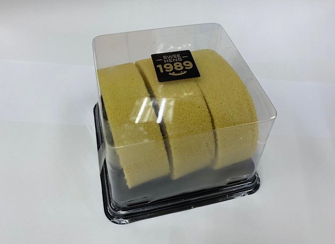A sliced cake roll in a clear plastic container with the 'Swee Heng 1989 Classic' label.