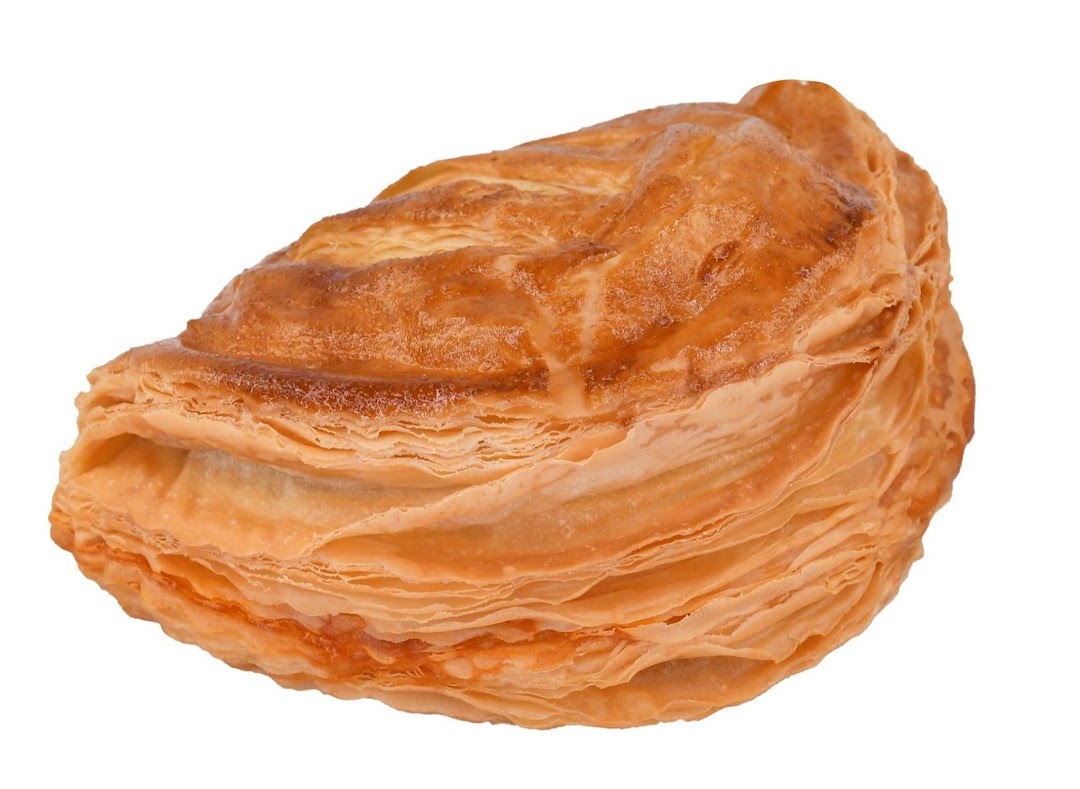 A close-up of a golden-brown, flaky pastry with a rich texture.