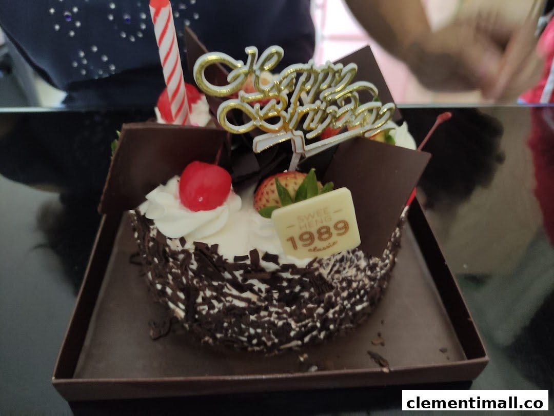 A delicious chocolate birthday cake from Swee Heng 1989 Classic, adorned with fruits and a 'Happy Birthday' topper.