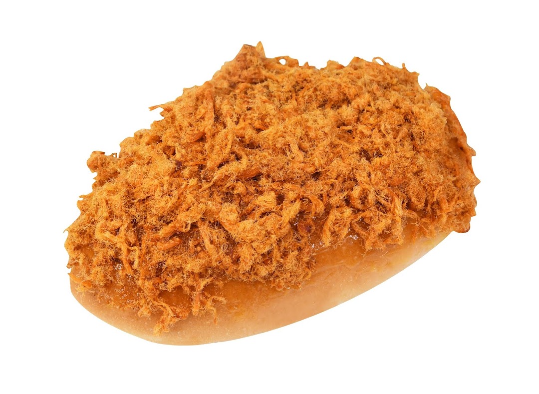 A close-up of a golden-brown bun generously topped with savory meat floss.