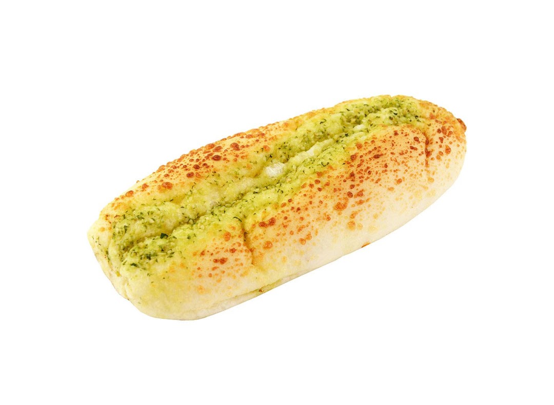 A close-up of a golden-baked bread roll topped with green herbs and orange sprinkles on a white background.