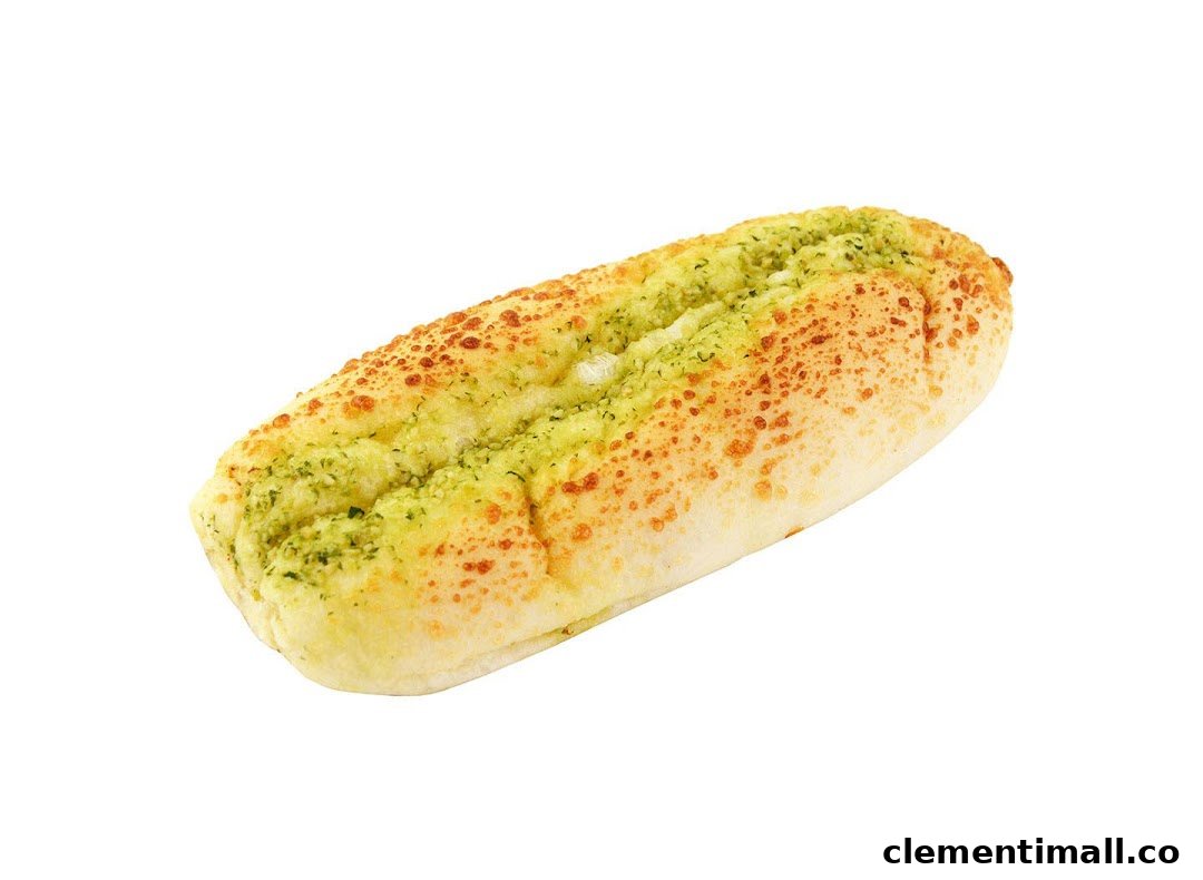 A close-up of a golden-baked bread roll topped with green herbs and orange sprinkles on a white background.