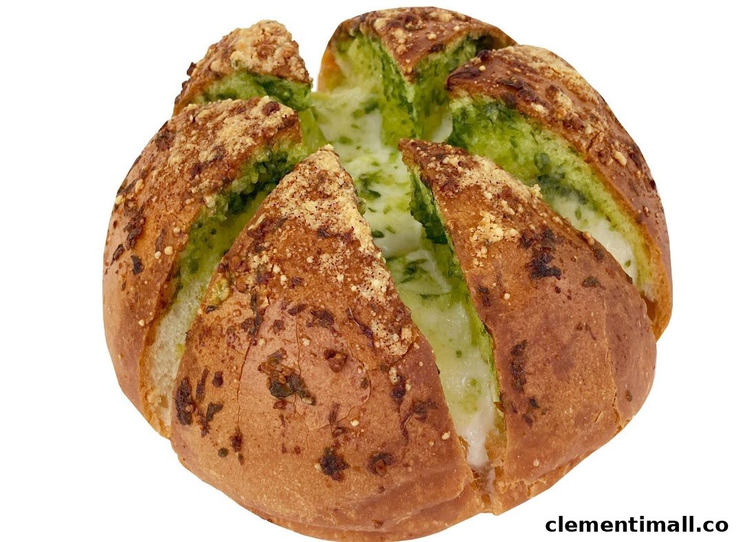 A round, golden-brown bread loaf with green pesto and melted cheese filling, topped with parmesan.