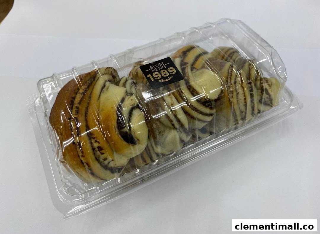 A clear plastic container holds several swirled chocolate and vanilla pastries from Swee Heng 1989 Classic.