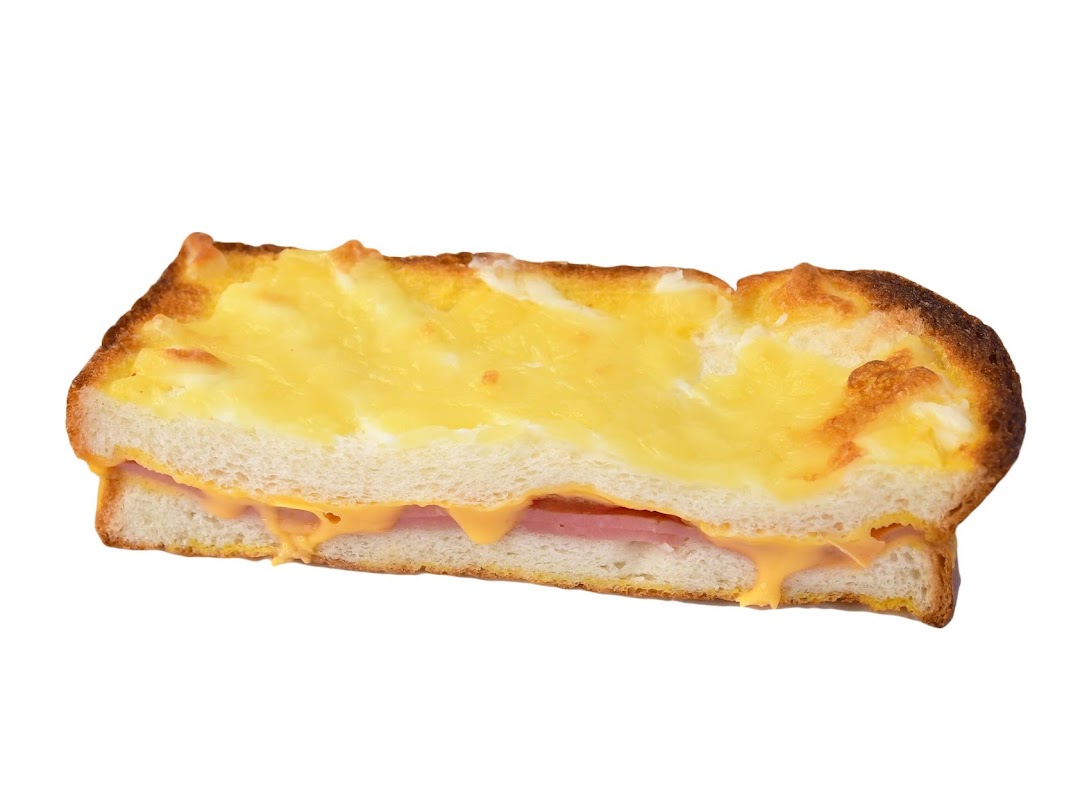 A close-up of a golden-brown baked toast with melted cheese and ham filling.