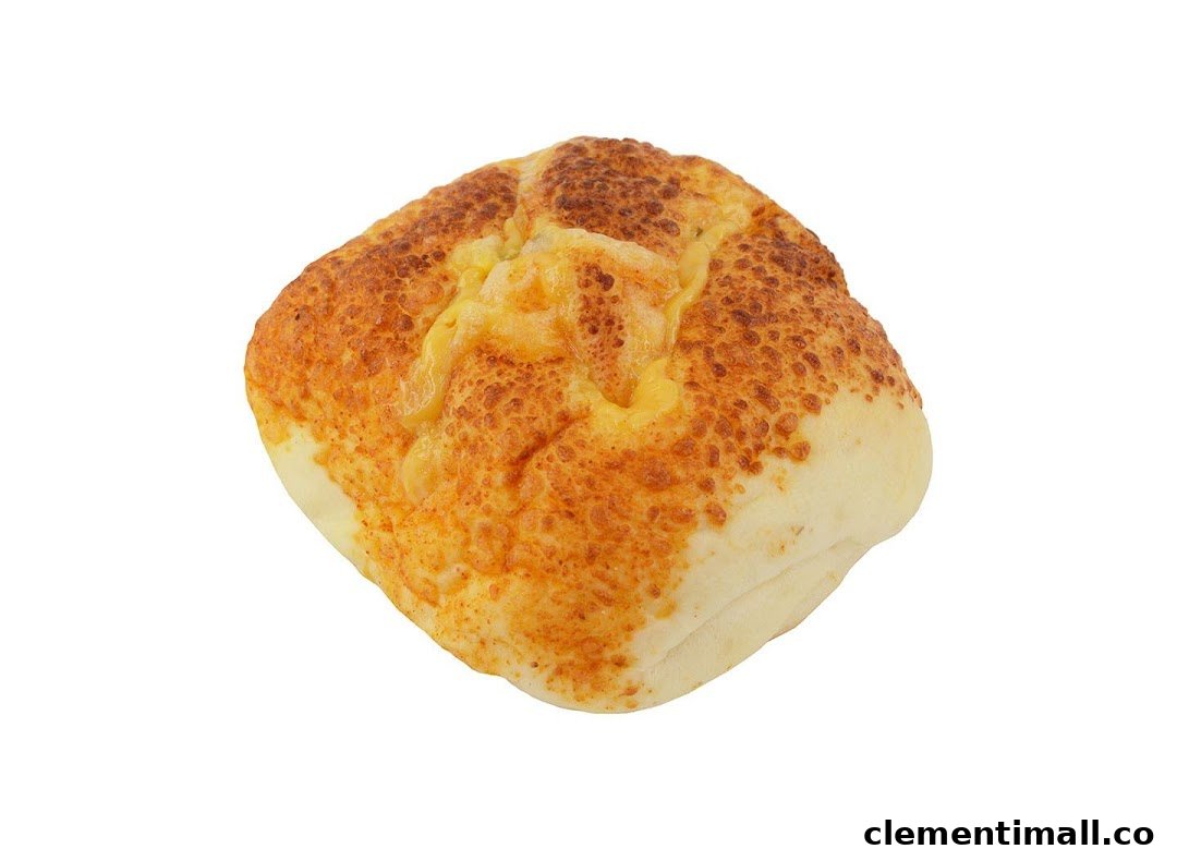 A golden-brown baked bun topped with melted cheese, isolated on a white background.