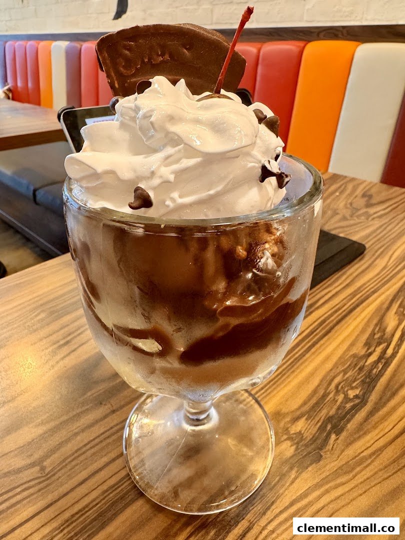 A delicious chocolate sundae with whipped cream, chocolate chips, and a cherry, served at Swensen's.