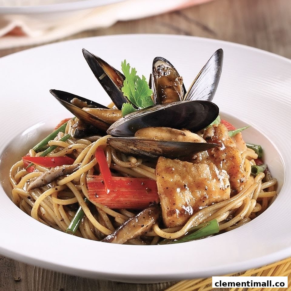A close-up of a delicious seafood spaghetti dish with mussels, fish, and vegetables in a white bowl.