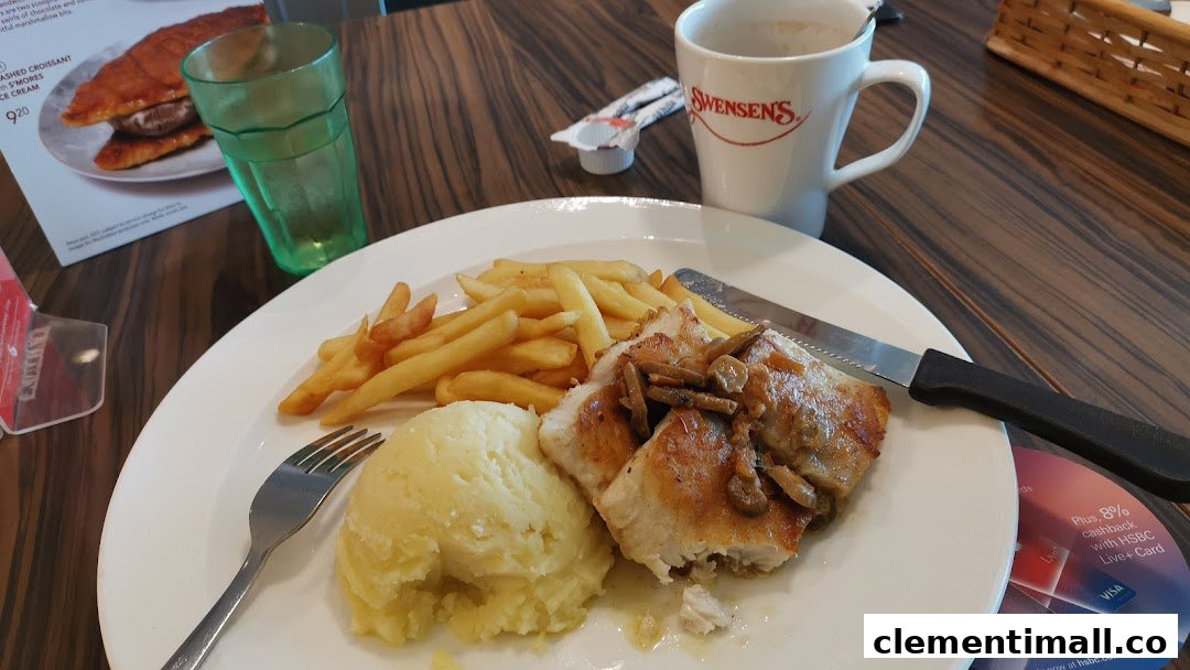 A close-up of a delicious meal with fries and mashed potatoes, a drink, and a Swensen's coffee cup.