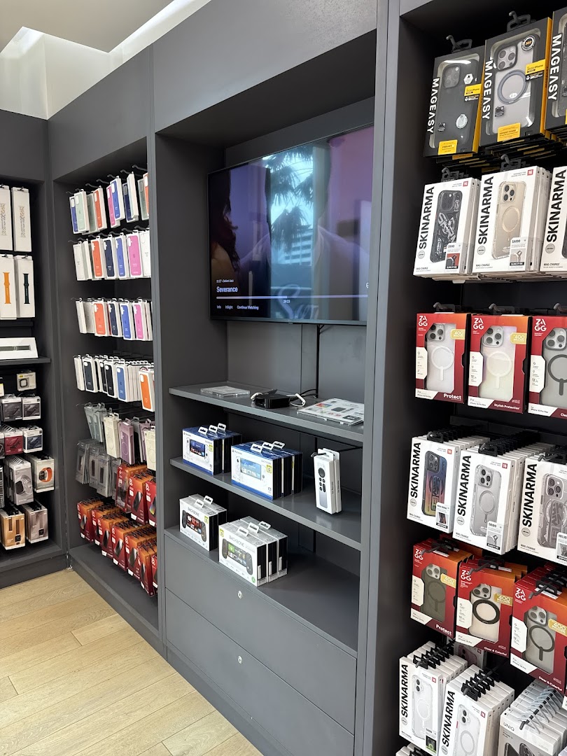 Interior view of an electronics accessories store showcasing phone cases, watch bands, and gadgets on display.