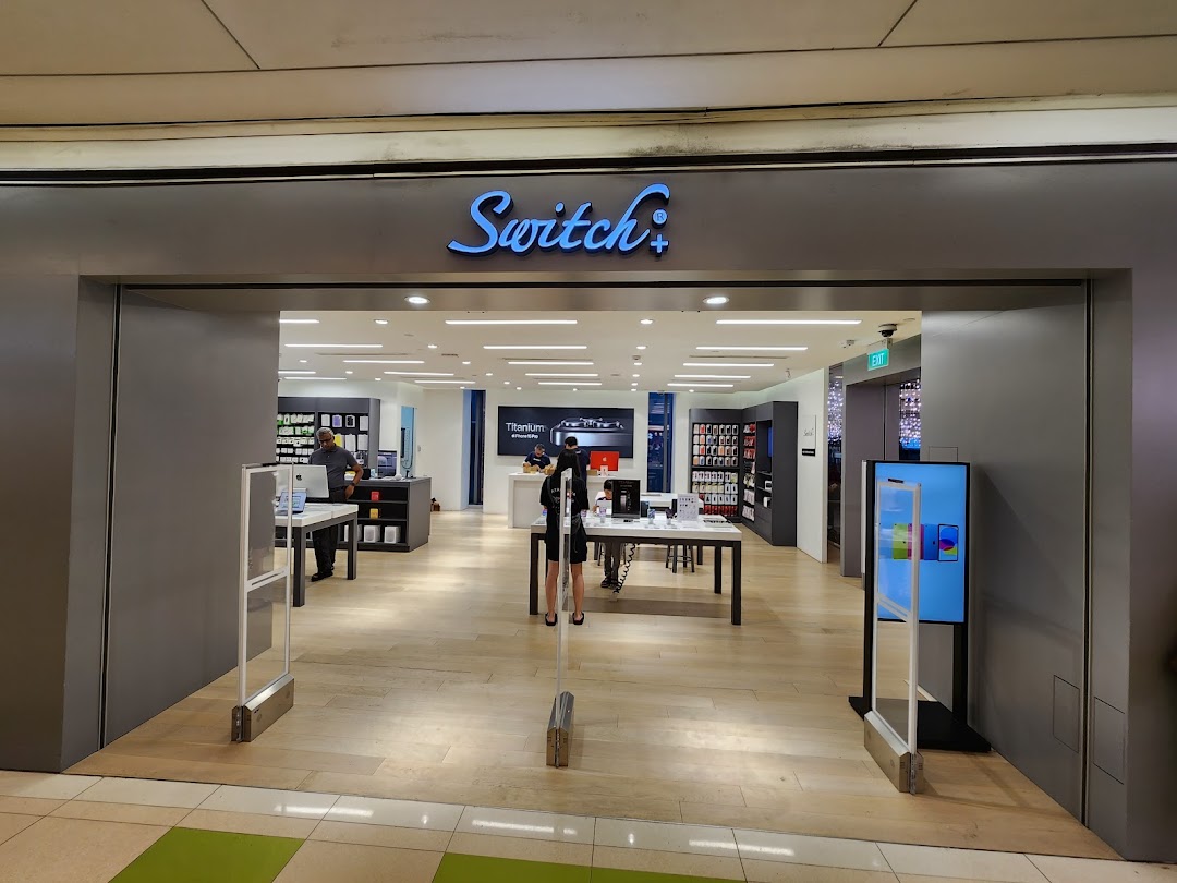 The entrance of Switch, an electronics store, showcasing Apple products and a bright interior.