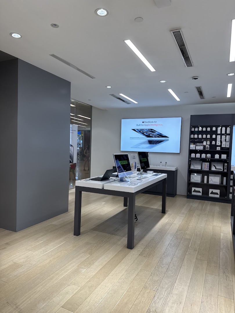 Interior view of Switch, an electronics store, showcasing Apple products on display tables and a large screen.