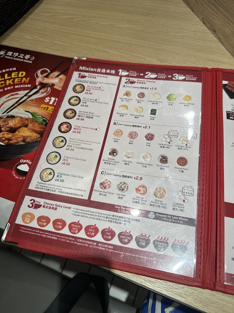 A detailed menu from TamJai SamGor Mixian, showcasing soup bases, toppings, and spice levels.